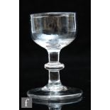 An 18th Century dram glass circa 1780, the ovoid bowl above a stem with medial bladed knop, raised