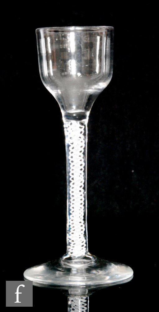 An 18th Century drinking glass circa 1765, the ogee bowl above a double series opaque stem with