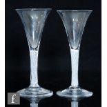 A pair of 18th Century drinking glasses circa 1760, the trumpet bowl above a single series opaque