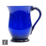 A Bristol blue drinking mug circa 1800, of footed ovoid form with everted rim and swan neck