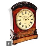 A 19th Century mahogany cased bracket clock of arched form, the case with a carved foliate frieze