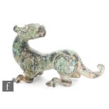 A Chinese bronze dragon figure, modelled in squat position with relief cast head turned, cast with