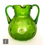An early 20th Century Loetz twin handled glass jug of ovoid form with twin lipped collar neck