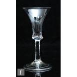 An 18th Century ale glass circa 1750, the waisted bell bowl above a plain stem and domed and