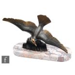 A 1930s Art Deco patinated spelter figure of a swooping seagull above rolling waves, mounted on a