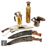 Three Kukri knives and scabbards including a white metal covered example, a brass hand sprayer, a