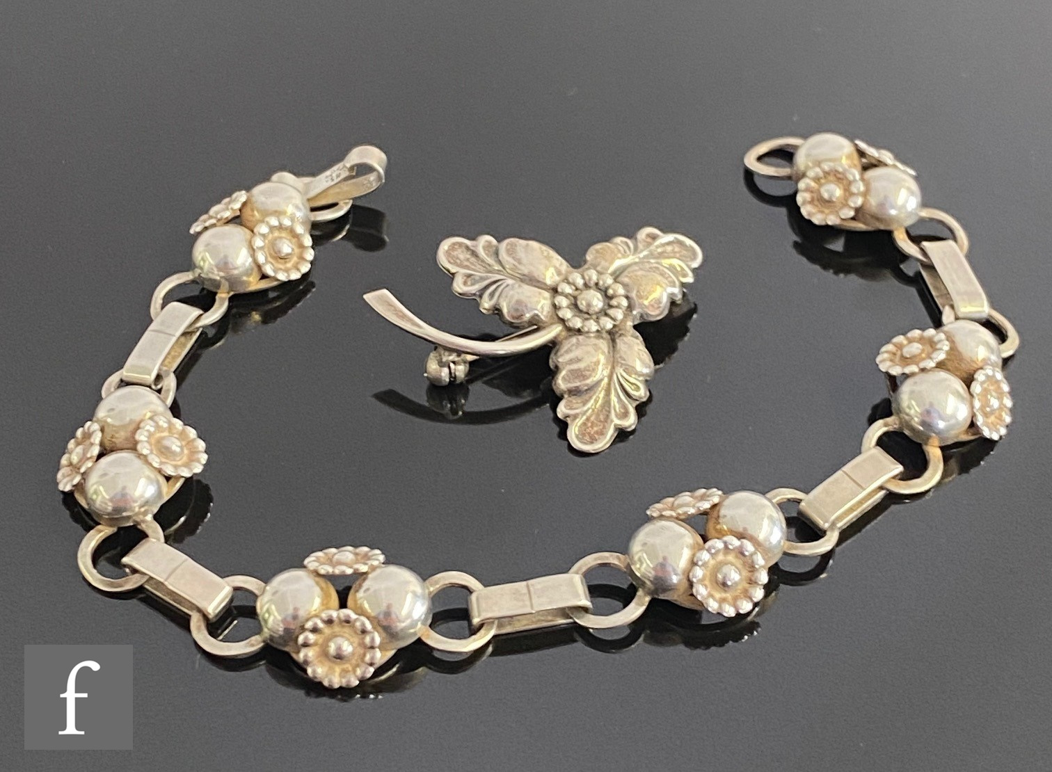 A Danish silver bracelet decorated with six stylised flower head sections, length 21cm, with a
