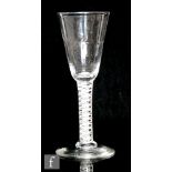 An 18th Century drinking glass circa 1760, the fluted round funnel bowl above a double series opaque