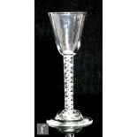 An 18th Century drinking glass circa 1750, the round funnel bowl above a mercury twist, raised to