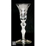 An 18th Century Jacobite drinking glass circa 1750, the bell bowl engraved with a six petalled