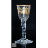An 18th Century wine glass circa 1785, the ovoid bowl with a gilt rim and further decorated in