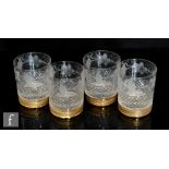 A set of four whisky or water tumblers each with an engraved grape vine garland above a diamond