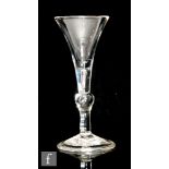 An 18th Century baluster Kit Kat type drinking glass, circa 1730, the trumpet bowl above a plain