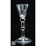 An 18th Century drinking glass circa 1740, the round funnel bowl over a plain stem with shoulder,