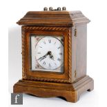 An oak cased mantle clock, the interior fitted with three drawers enclosed by a battery operated