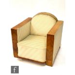 An Art Deco walnut veneered armchair, with a cloud shaped back and quarter veneered strut style