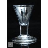 An 18th Century dram glass circa 1740, the flared trumpet bowl above a short plain stem and raised
