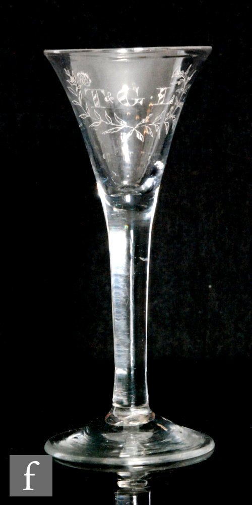 An 18th Century drinking glass circa 1750, the trumpet bowl engraved T & G.L linked with a rose