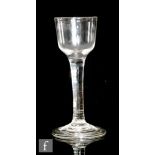 An 18th Century drinking glass circa 1750, the ogee bowl above a solid plain stem, raised to a