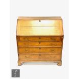 A George III oak fall front bureau, the hinged fall enclosing a fitted interior above four graduated