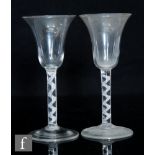 A pair of 18th Century drinking glasses circa 1750, the bell bowls above single series air twist