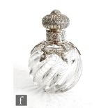 A Victorian hallmarked silver and clear glass globular scent bottle, the wrythen glass below