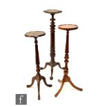 A group of three 20th Century mahogany jardiniere stands or torcheres, with reeded columns over