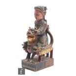 A Chinese late Qing Dynasty (1644-1912) carved and painted wooden warrior figure, carved in relief