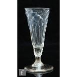 An 18th Century dwarf ale glass, the round funnel bowl wrythen moulded above a short milled stem,