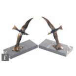 A pair of 1930s patinated spelter figures of seagulls in flight, above crashing waves, mounted on