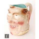 A Sarreguemines character jug modelled as a comical face with rosy cheeks, impressed mark, height