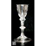 An 18th Century drinking glass circa 1750, the round funnel bowl above a balustroid stem with