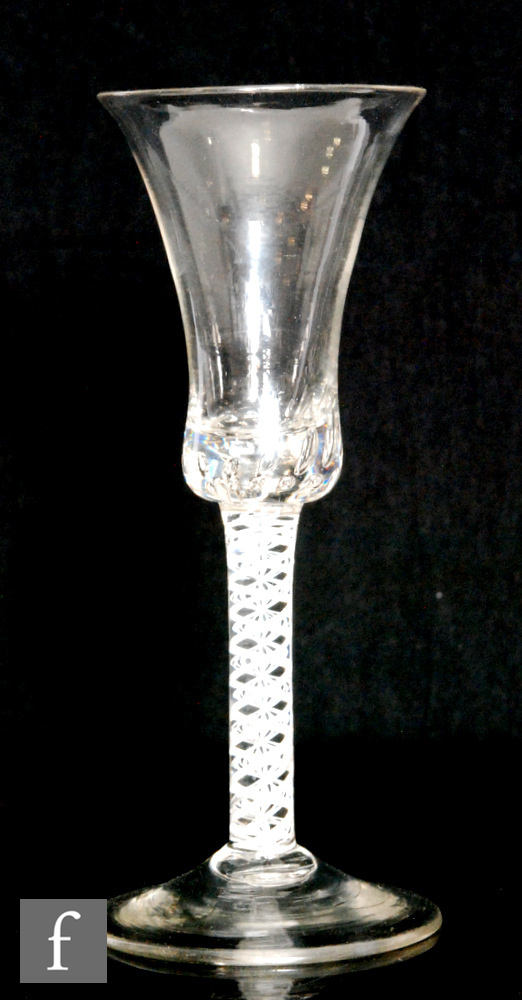 An 18th Century drinking glass circa 1770, the bell bowl with solid teared base above double