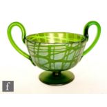 In the manner of Loetz an early 20th Century glass twin handled pedestal cup in green with a