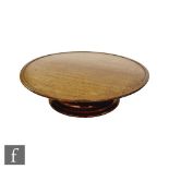 An Arts and Crafts oak lazy susan, the circular top with a moulded rim above a stepped thumb-moulded