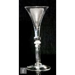 An 18th Century drinking glass circa 1740, the drawn trumpet bowl above a multi knopped stem with