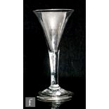 An 18th Century drinking glass circa 1740, the trumpet bowl above plain teared stem, raised to a