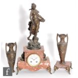 A late 19th to early 20th Century French rouge marble and spelter clock garniture, the clock with