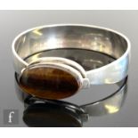 A Danish silver and tigers eye bangle, central oval tigers eye, length 25mm, collar mounted above