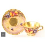 A later 20th Century matched Royal Worcester Fallen Fruits teacup and saucer, the teacup decorated