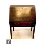 A George III oak writing desk, fitted with a drawer interior enclosed by a plain fall over a
