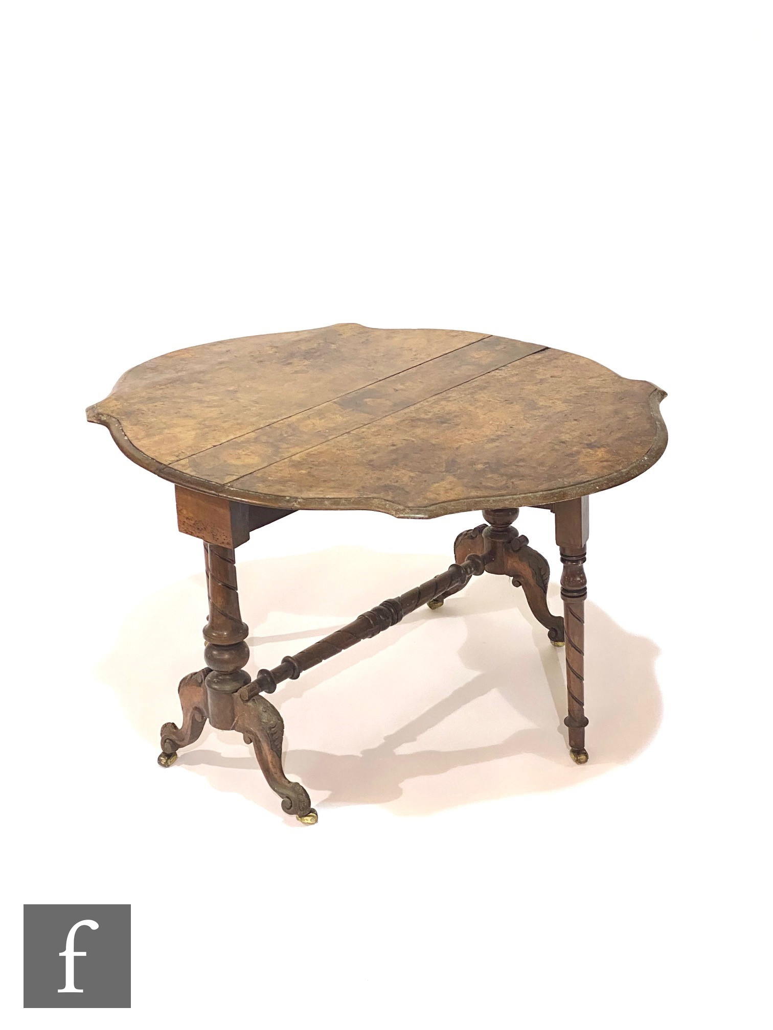 A Victorian figured walnut Sutherland table with shaped drop flap top, on turned supports and carved