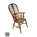 An early 20th Century ash and elm seat stick back Windsor elbow chair, on turned splayed legs united