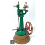A vertical live steam engine with single oscillating cylinder and centrifugal governor, painted in
