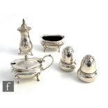 A hallmarked three piece boat shaped cruet set with a pair of silver peppers modelled as a acorns,