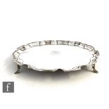 A hallmarked silver circular salver with central engraved initials to a plain ground within raised