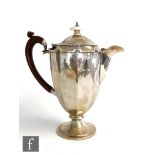 A hallmarked silver pedestal coffee pot of plain faceted form with castellated border, wooden scroll