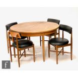 A G-Plan circular teak dining table, diameter 123cm, and a set of four black vinyl upholstered