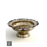 A hallmarked silver pedestal bowl, circular stepped foot below plain body and pierced scroll border,