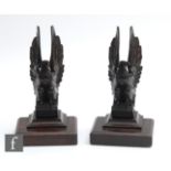 A pair of late 19th and early 20th Century carved mahogany eagle bookends, each on stepped plinth